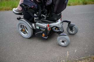 Eine Person sitzt in einem Elektrorollstuhl