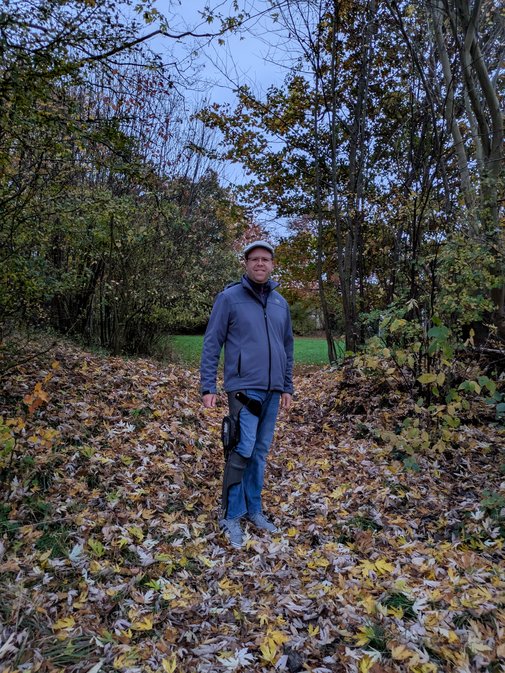 Jan H&ouml;rberg steht auf einem Weg in einem herbstlichen Wald, er tr&auml;gt seine Orthese am Bein