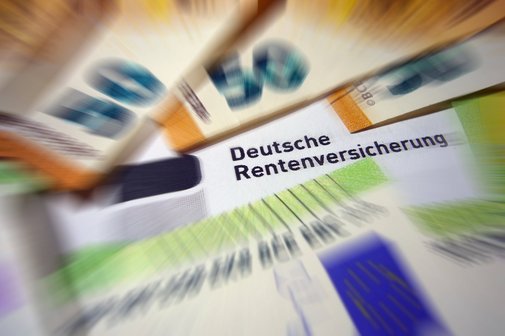 Geldscheine liegen auf einem Rentenbescheid der Deutschen Rentenversicherung 