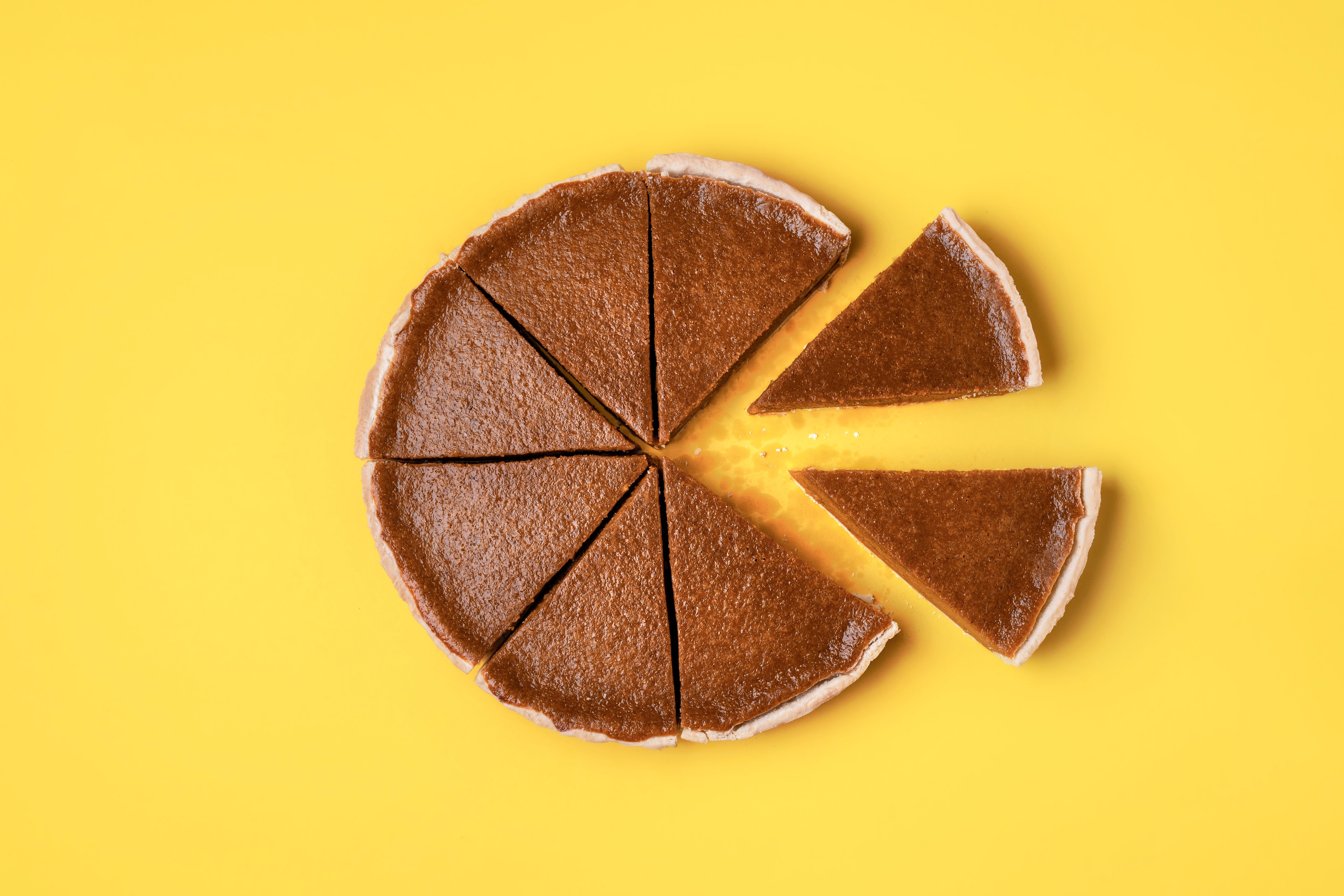 Teilrente Angeschnittener runder Kuchen vor gelbem Hintergrund, mehrere Teile sind wie bei einem Kreisdiagramm vom Kuchen entfernt worden als Symbol für Teile einer Rente.