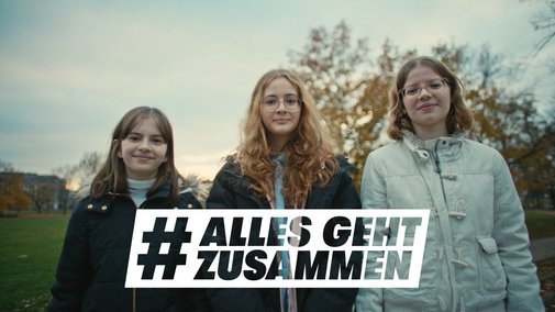 Alles geht zusammen - Junge Menschen Drei jugendliche Mädchen stehen nebeneinander, blicken frontal in die Kamera. Darüber das Logo der Aktion Alles geht zusammen.
