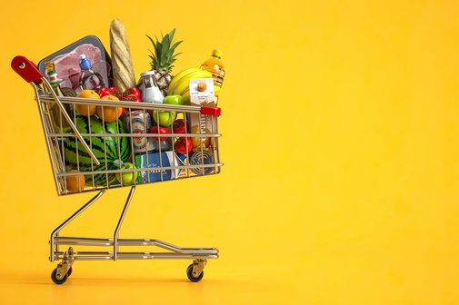 Ein kleiner Spielzeug-Einkaufswagen, gefüllt mit Miniaturen von Lebensmitteln