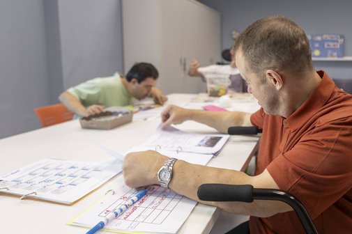 Mehrere Männer bei der Arbeit in einer Behindertenwerkstatt.