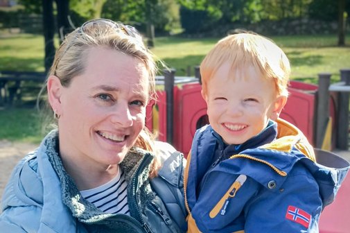 Tanja Freter und ihr Sohn Jarik Tanja Freter hält ihren Sohn auf dem Arm, im Hintergrund sieht man einen Spielplatz. Beide lachen in die Kamera.