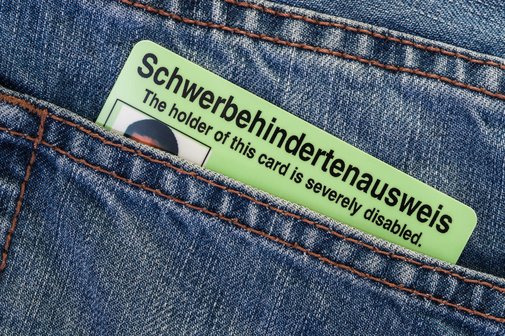 Schwerbehindertenausweis Eine hintere Jeanstasche, aus der ein Schwerbehindertenausweis im Scheckkartenformat herausschaut.