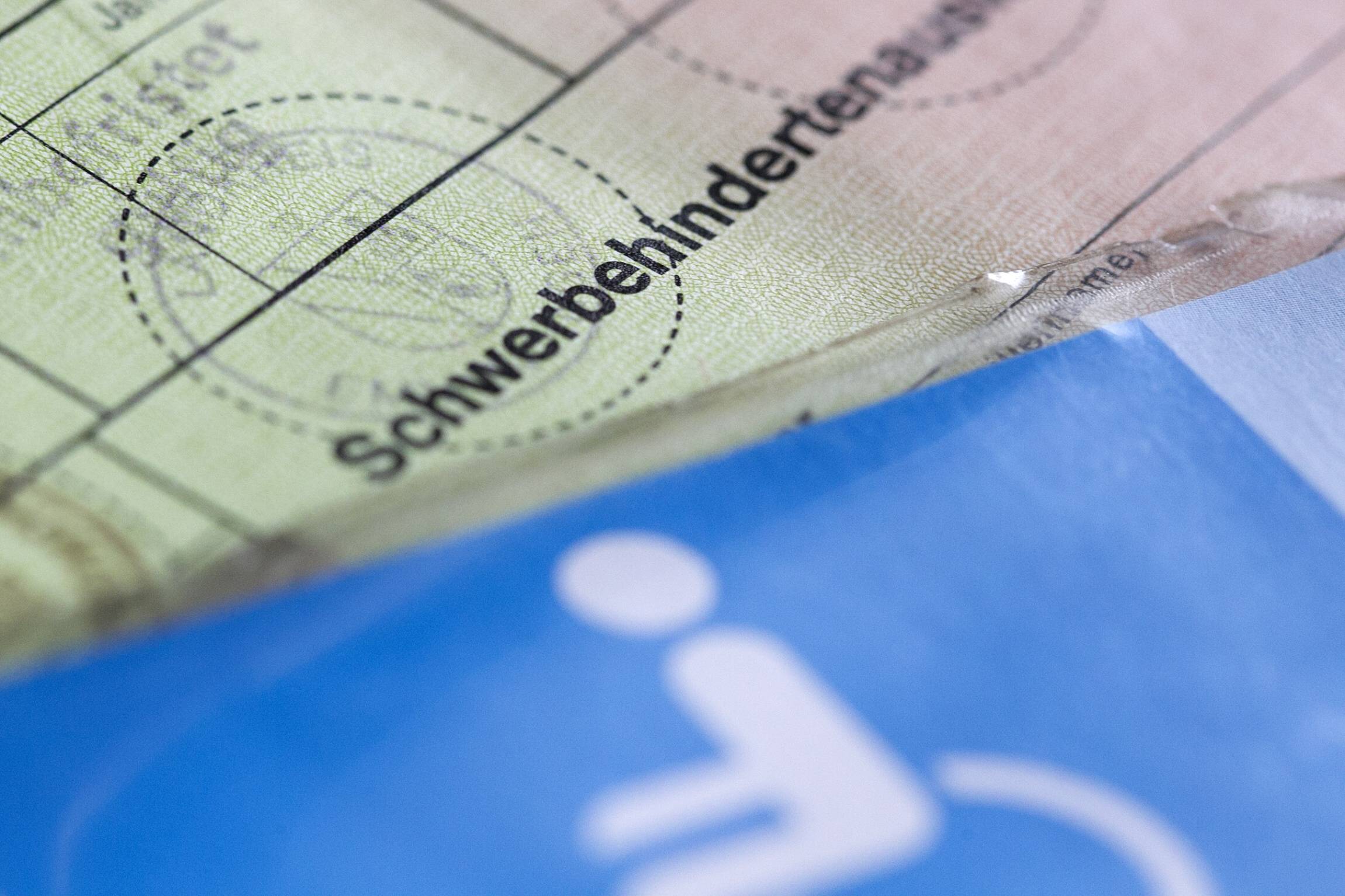 Schwerbehindertenausweis Ein Schwerbehindertenausweis im alten Format. Darauf ist ein Parkausweis für schwerbehinderte Menschen mit dem blauen Rollstuhl-Piktogramm zu erkennen.