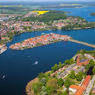 Luftbild von der Inselstadt Malchow in der Bildmitte. Unten die Klosterkirche, recht der Erddamm und im Hintergrund ein Teil der Mecklenburgischen Seenplatte.